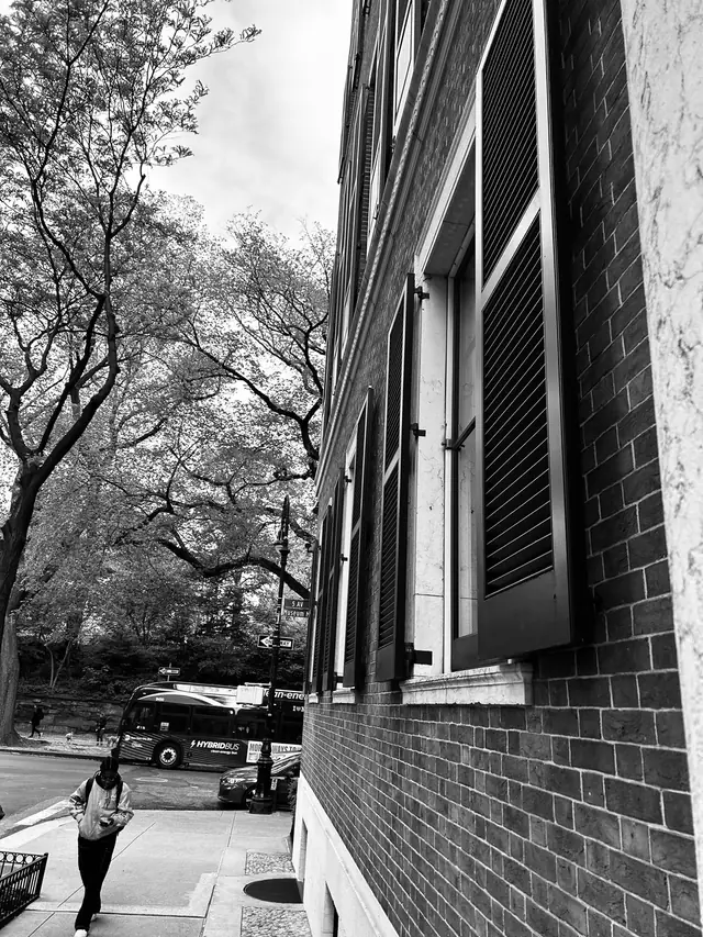 A black and white New York brick wall with shuttered windows